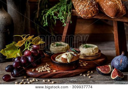 Soft Spreadable French Stinky Cheese On A Slice Of Bread With Fruit And Pine Nuts