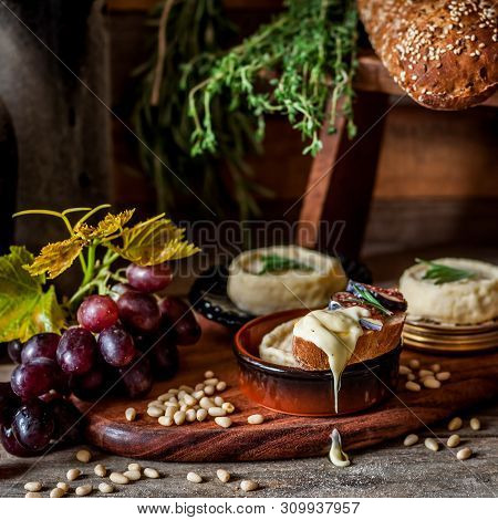 Soft Spreadable French Stinky Cheese On A Slice Of Bread With Fruit And Pine Nuts, Square