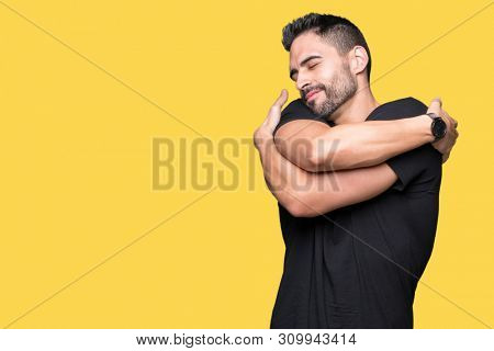 Young handsome man over isolated background Hugging oneself happy and positive, smiling confident. Self love and self care