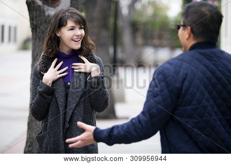 Female Pedestrian Walking Into A Friend By Coincidence On The Street.  They Are Meeting And Greeting