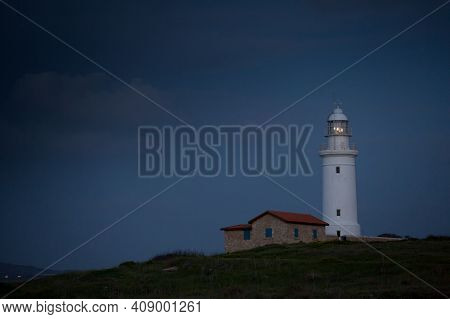 White Beautiful Lighthouse On The Background Of The Night Blue Sky. Cyprus. Pathos.