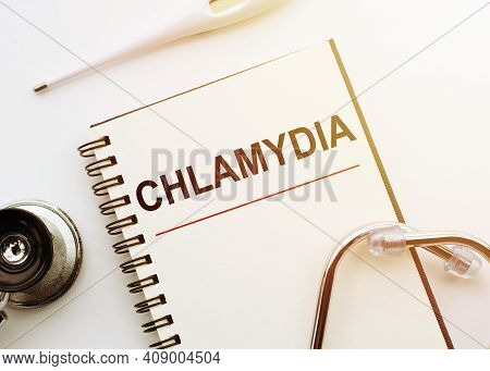 Medical Concept. Notebook With Word Chlamydia On White Desk With Stethoscope And Thermometer.