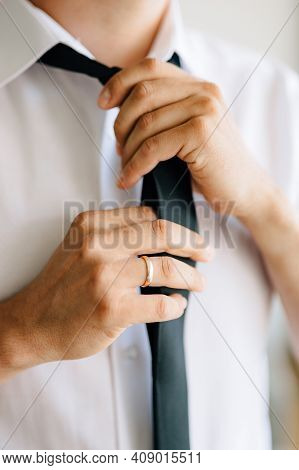 A Man Puts On And Ties A Tie While Preparing For A Wedding Ceremony, Close-up
