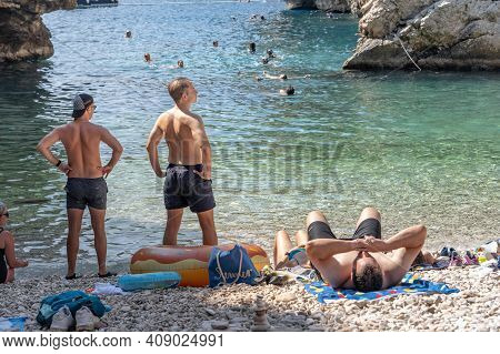 Vis, Croatia - Aug 17, 2020: Tourists Sunbathing On Sheltered Cove Stiniva Beach In Summer