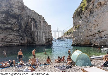 Vis, Croatia - Aug 17, 2020: Tourists Sunbathing On Sheltered Cove Stiniva Beach In Summer
