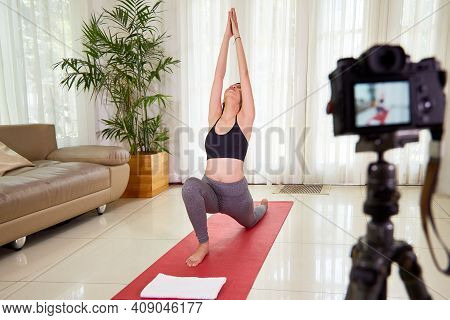 Female Fitness Blogger Filming Video On Doing Crescent Lunge Oga Pose At Home