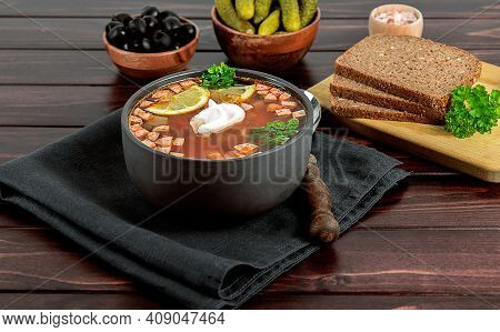 Solyanka Or Soljanka, Russian And East European Soup With Sausage, Olives, Pickled Cucumber, And Cap