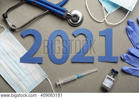 Flat Lay Composition With Coronavirus Vaccine And Number 2021 On Grey Background