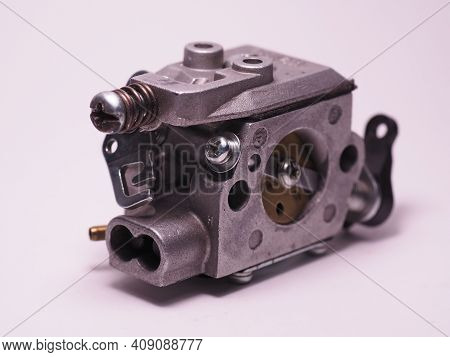 Chainsaw Carburetor On A White Background. Chainsaw Spare Part. Carburettor Adjustment