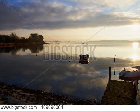 Magical Tranuil Beautiful With Clear Calm Water Sunset With Great Clouds Formation By The Sea Shore 