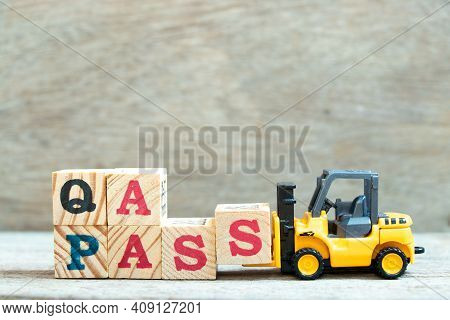Toy Forklift Hold Letter Block S To Complete Word Qa (quality Assurance) Pass On Wood Background