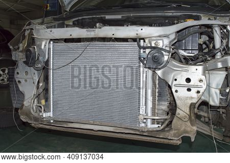 A New Radiator Is Installed On A Gray Car In A Car Service Station. View With The Front Bumper Remov