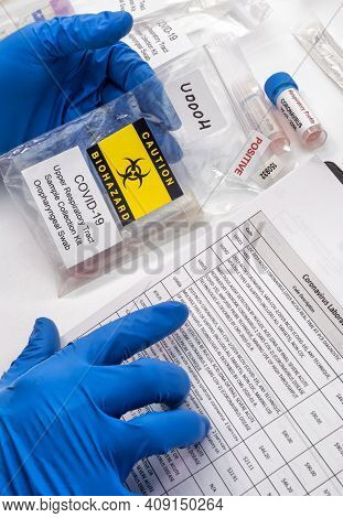 Nurse Comparing Positive Covid-19 Test Results Of Infected Persons, Selecting Codes On Label Accordi