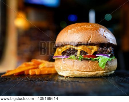 Elicious Burger With Sauce. Hamburger. Delicious Grilled Angus Burger With Cheese, Salad And Tomatoe