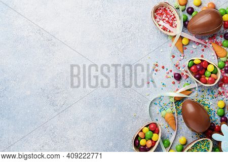 Chocolate Easter Eggs And Colorful Sweets On Gtay Background Greeting Card. Top View. Flat Lay With 