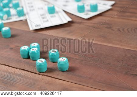 Many Barrels With Numbers And Cards For Lotto Or Russian Bingo Table Game On Wooden Surface. Russian