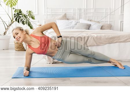 Young Athletic Smiling Woman Practicing Yoga Doing Vasishthasana Exercise, Side Plank Pose, Workout,