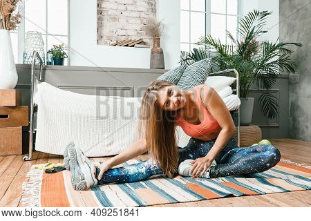 A Young Woman Goes In For Sports At Home, Online Workout . The Athlete  Stretching , Meditating, Sit