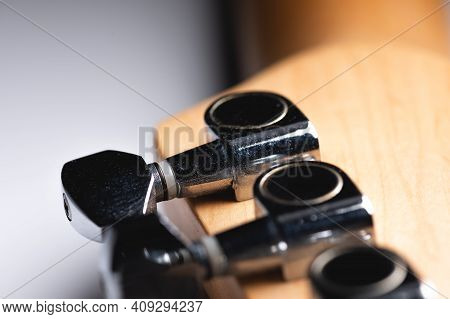 Guitar Fretboard With Tuning Pegs And Strings On A Gray Background. Close-up