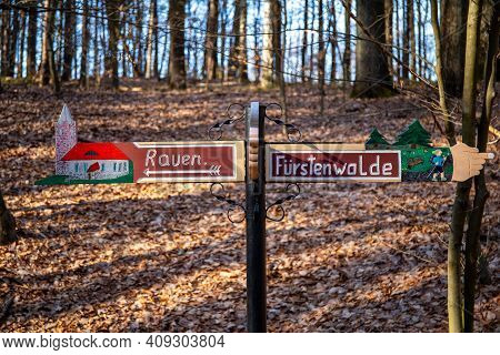 Rauen, Brandenburg, Germany - February 21, 2021 Sign In The Forest - Shows The Direction To Rauen An