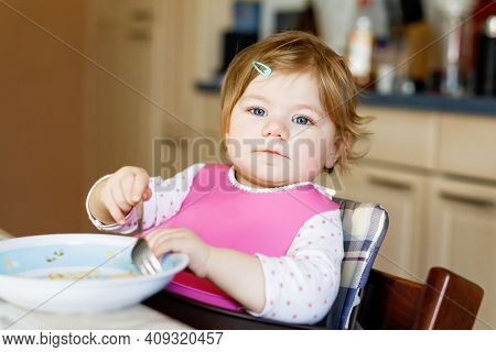 Adorable Baby Girl Eating From Spoon Mashed Vegetables And Puree. Food, Child, Feeding And People Co