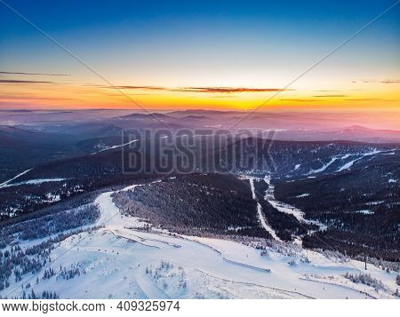 Colorful Winter Sunset In Sheregesh Ski Resort Mountains With Clouds. Aerial Top View Forest Russia