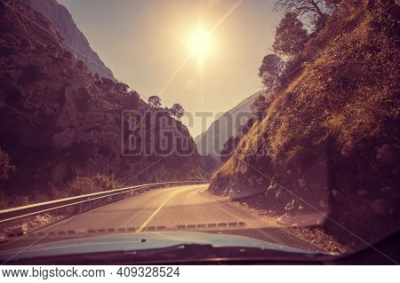 View Of Beautiful Mountain Landscape Through The Windscreen On A Sunny Day. Driving A Car On Mountai