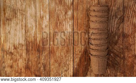 Empty Peat Pots For Seedlings On A Wooden Background. Gardening. The Concept Of Preparing Garden Too