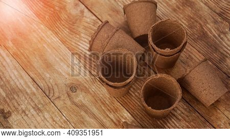 Empty Peat Pots For Seedlings On A Wooden Background. Gardening. The Concept Of Preparing Garden Too
