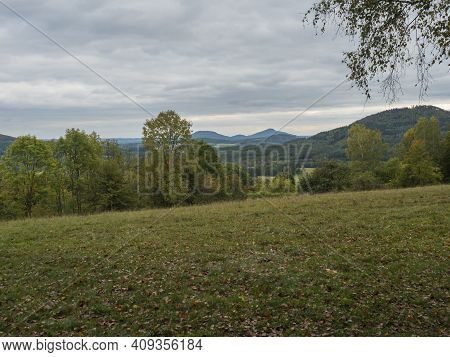 Meadow With Autumn Colorful Forest, Trees And Hills, Moody Sky. Landscape In Luzicke Hory Lusatian M