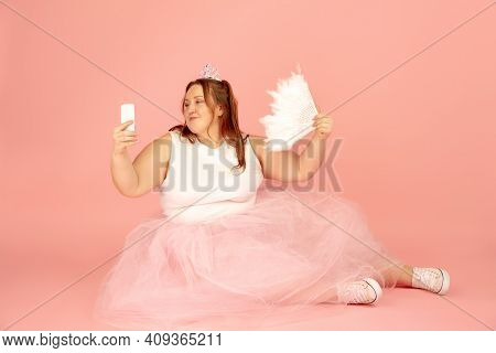 Selfie. Beautiful Plump Caucasian Plus Size Model In Fairys Outfit Isolated On Pink Studio Backgroun