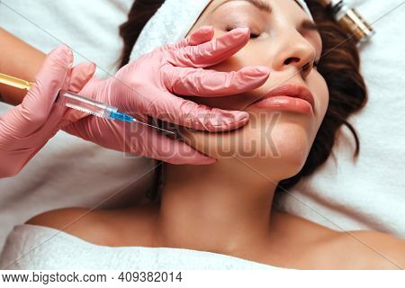 The Doctor Gives An Injection Into The Woman's Cheekbone. Cosmetology