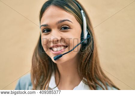 Young latin call center aget girl smiling happy using headset at the city.