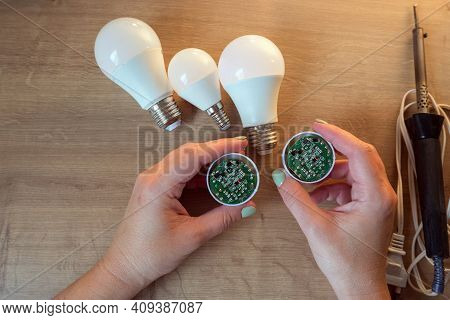 Woman Repairing A Led Lamp With A Soldering Iron