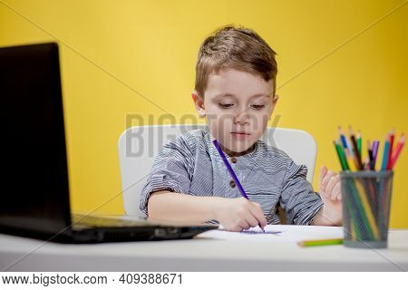 Happy Child Using Digital Laptop Doing Homework On Yellow Background. Social Distancing, E-learning