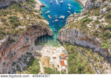 Aerial View Of Tourists Sunbath Swim At Stiniva Cove Beach Of Adriatic Sea On Vis Island In Croatia 