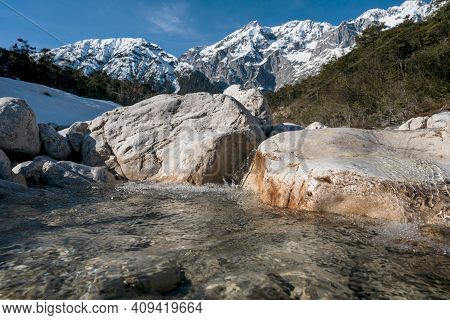 Clear Mountain River Flowing Over Rocks Through Evergreen Forest With Last Snow, Mieminger Plateau, 