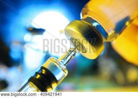 Filling Syringe With Vaccine From Vial On Blurred Background, Closeup