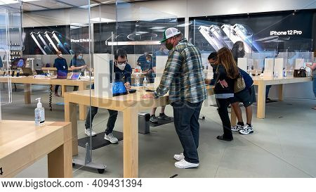 Apple Employees Waiting On Customers With Plexiglass Sheilds Between While Wearing Face Masks Due To