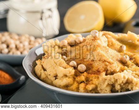 Homemade Hummus With Olive Oil In Gray Bowl And Ingredients. Traditional Middle Eastern Appetizer Hu
