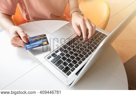 Close Up Of Someone Hand Holding Credit Card During Using Laptop For Online Shopping. Online Shoppin
