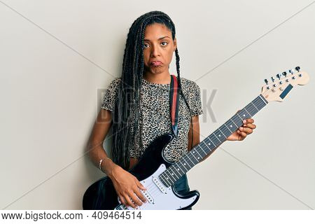 African american woman playing electric guitar depressed and worry for distress, crying angry and afraid. sad expression. 