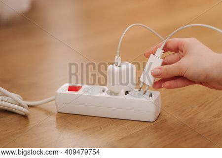 Woman Pluging The Wire Into White Extension Cord. Close Up Of Female Hand Put Cabel