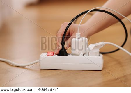 Woman Pluging The Wire Into White Extension Cord. Close Up Of Female Hand Put Cabel