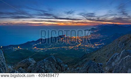 The View From The Mountain Rumija At Sunset. Evening Lights Of The Bar City. Mediterranean Sea, Mont