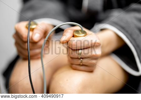 Woman Takes Hold Of The Brass Handpieces Of Bioenergetic Testing Device