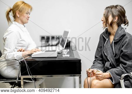 Woman Takes Hold Of The Brass Handpieces Of Bioenergetic Testing Device