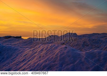 Blocks Of Ice On The Seashore At Sunset At A Frosen Baltic Sea