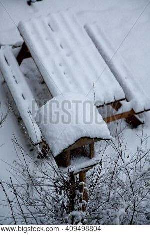 Close-up Of Garden Bench And Bird Table Covered In Thick Fresh Snow