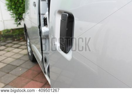 Black Car Door Handle On The Sliding Door Of A Silver Car